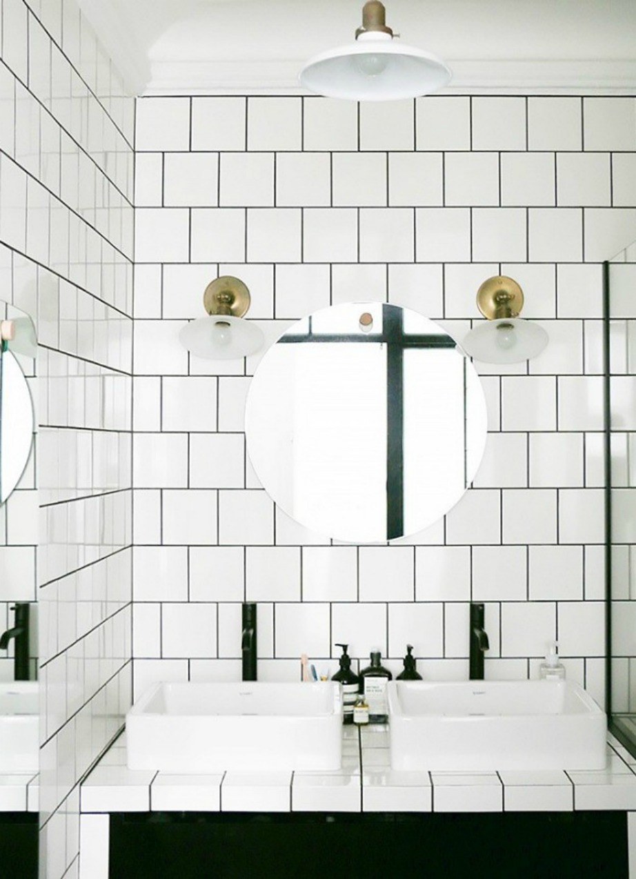 Τα φωτιστικά από ορείχαλκο προσθέτουν στιλ σε αυτό το μπάνιο που έχει 'ντυθεί' με τετράγωνα πλακάκια.