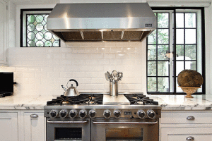 Οι οικιακές συσκευές της κουζίνας είναι από ανοξείδωτο ατσάλι ενώ το μαύρο περίγραμμα στα κουφώματα των παραθύρων κάνουν την απόλυτη αντίθεση σε ένα κατά τα άλλα ήσυχο περιβάλλον της κουζίνας. 