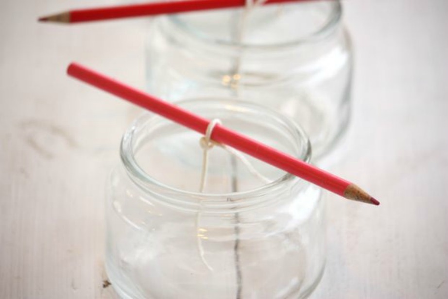 Τυλίξτε την άκρη του φυτιλιού από ένα μολύβι και στηρίξτε το στο στόμιο του δοχείου που λειτουργεί ως καλούπι. 